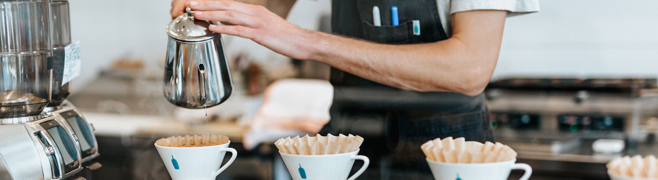 Mitarbeiter schenkt Kaffee ein 