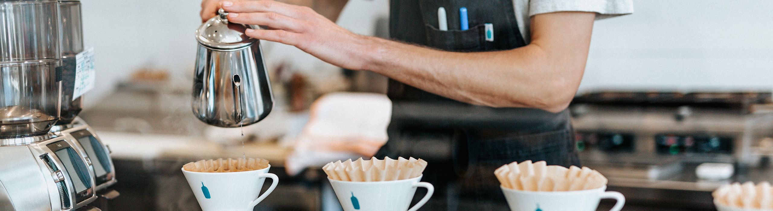 Mitarbeiter schenkt Kaffee ein